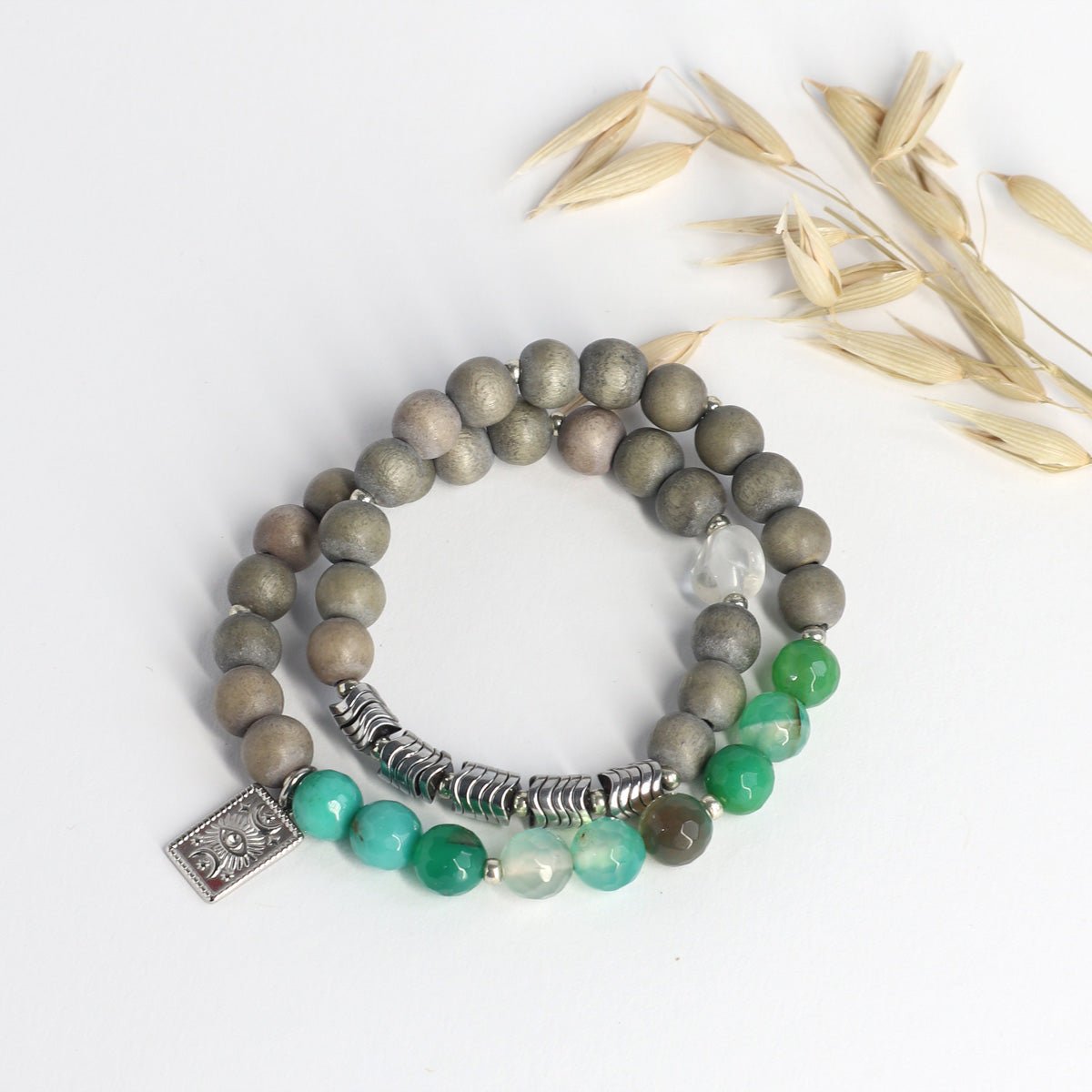 Wickel-Edelstein Armband aus grünen Achat- und Holzperlen mit silbernem Augenanhänger auf Weiß