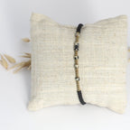Morsecode Armband Selflove mit schwarzen und goldenen Perlen auf Stoffkissen präsentiert