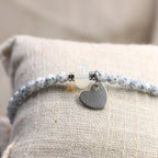 Nahaufnahme des 10 mm silbernen Herz-Anhängers aus Edelstahl an einem blauen 4 mm Perlenarmband
