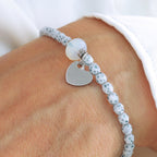 Blaues Perlenarmband aus 4 mm Perlen mit silbernem 10 mm Edelstahl-Herz am Handgelenk getragen