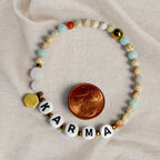 Karma Armband flach liegend mit Mondstein und Cent-Münze als Größenvergleich. trueffeldesign