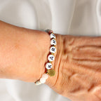Karma Armband mit Mondstein-Perlen und Buchstaben-Perlen getragen am Handgelenk. trueffeldesign