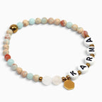Karma Armband aus Mondstein und bunten Edelstein-Perlen auf weißem Hintergrund. trueffeldesign