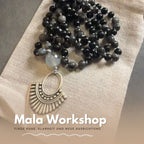 Dunkle Mala Kette mit großem Anhänger auf Stoffunterlage beim Workshop