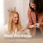 Zwei Frauen überreichen Schmuckschachtel beim Mala Workshop lächelnd