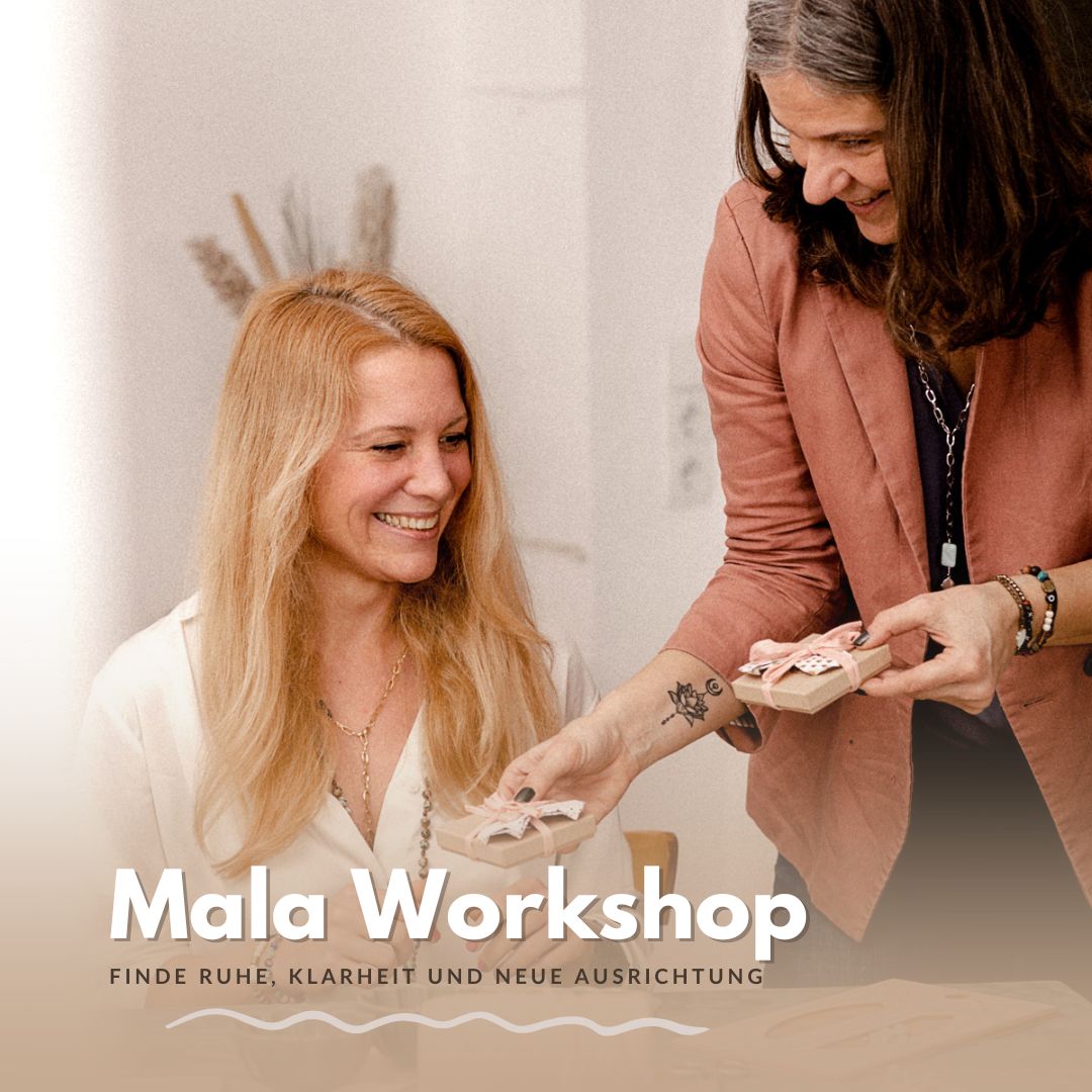 Zwei Frauen überreichen Schmuckschachtel beim Mala Workshop lächelnd