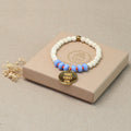 Mantra Schmuck Damen – blaues Perlenarmband mit goldenem Plättchen auf beiger Geschenkbox
