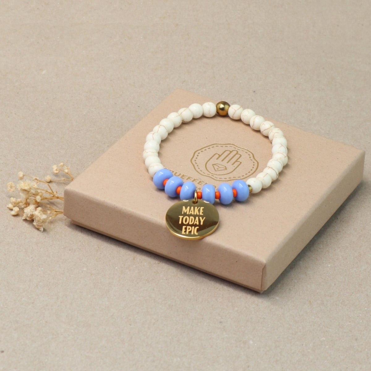 Mantra Schmuck Damen – blaues Perlenarmband mit goldenem Plättchen auf beiger Geschenkbox