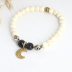 Mond Armband aus Blaufluss, Dalmatiner Jaspis und Hämatit mit goldfarbenem Mondanhänger auf hellem Hintergrund