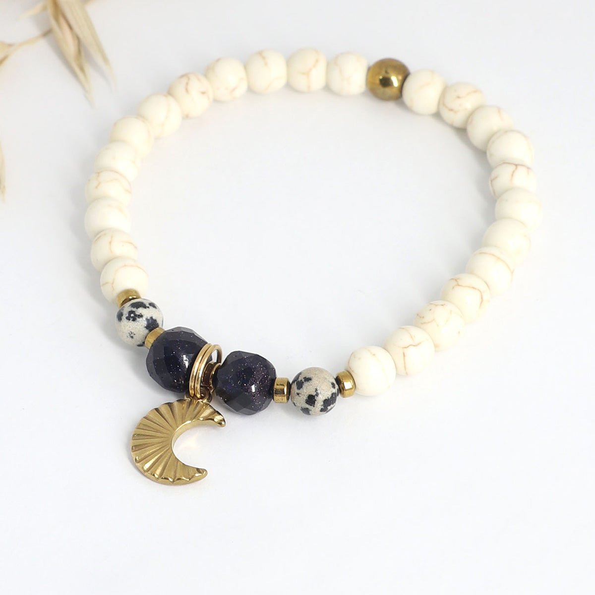Mond Armband aus Blaufluss, Dalmatiner Jaspis und Hämatit mit goldfarbenem Mondanhänger auf hellem Hintergrund