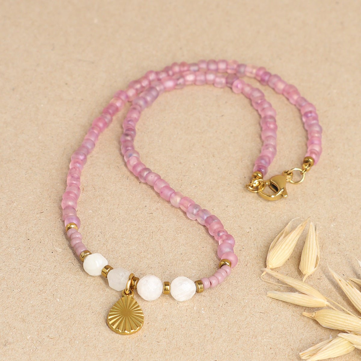 Schlichte Mondstein Kette mit Edelstahl liegt auf einem beigen Hintergrund