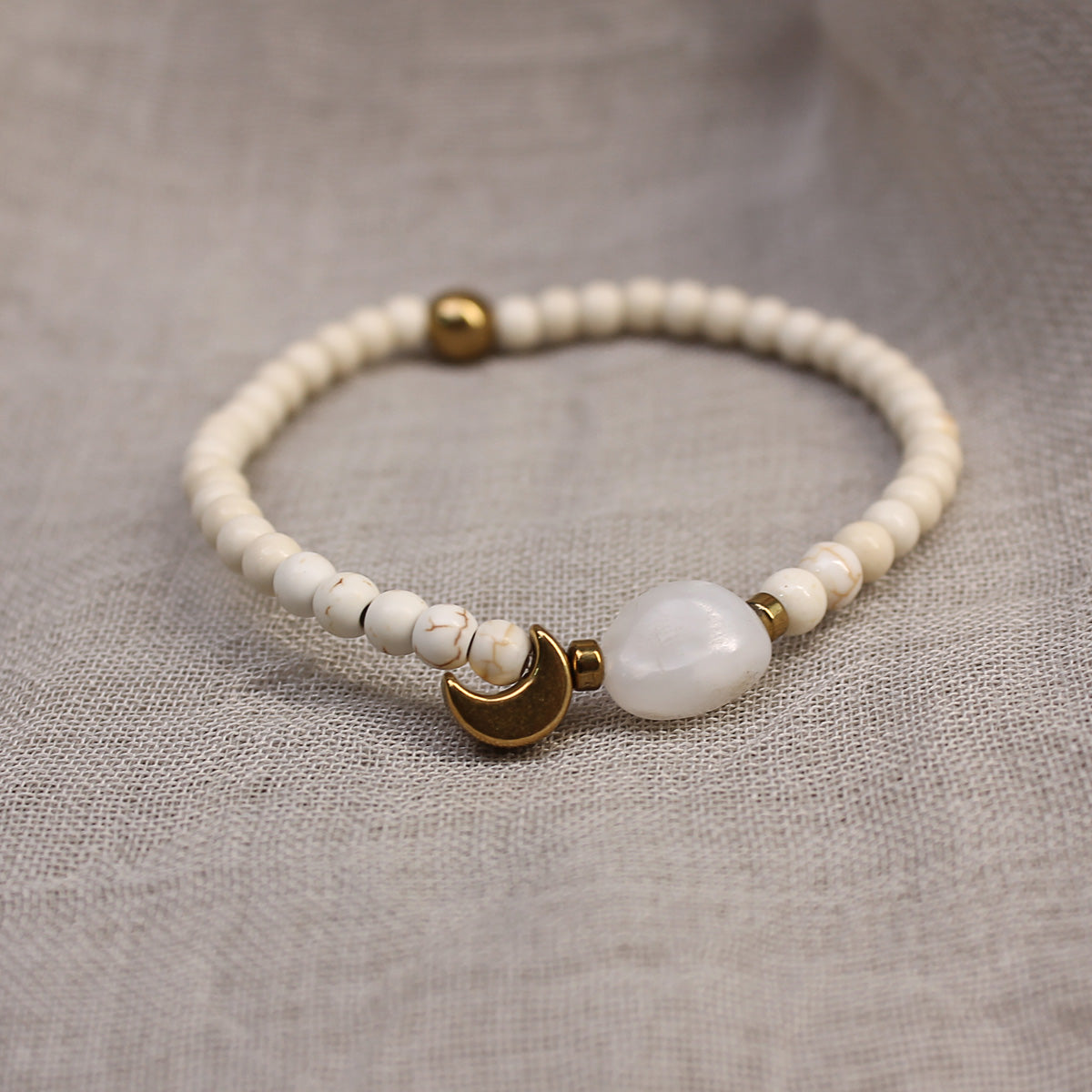 Vorderansicht des filigranen Damen-Perlenarmbands mit vergoldetem Halbmond-Anhänger und echtem Mondstein.