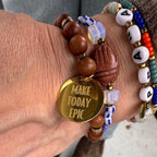 Perlenarmband aus Natursteinen und Holz kombiniert mit anderen bunten Perlenarmbändern als Layering-Look.