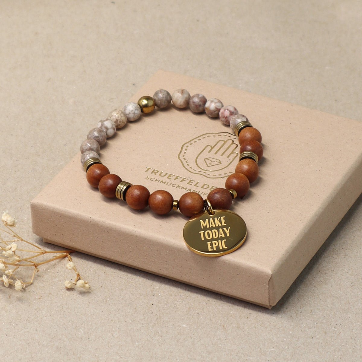 Sandelholz-Perlenarmband für Herren & Damen auf hellem Podest – minimalistisches Produktfoto mit goldenem Anhänger