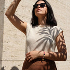 Frau trägt bedeutungsvollen Edelsteinschmuck von Trueffeldesign bei Sonnenlicht mit Palmenschatten | trueffeldesign