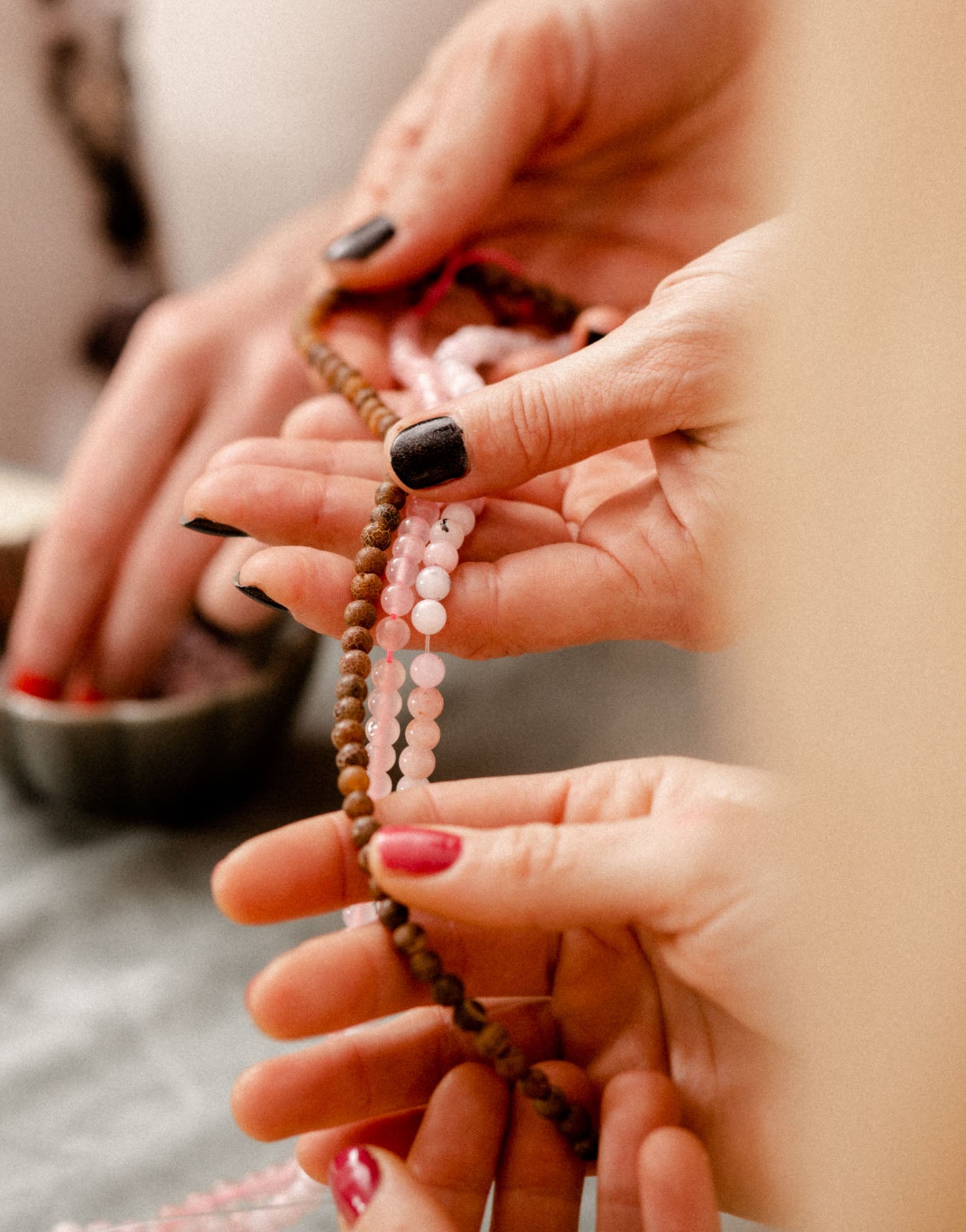 Nahaufnahme von Händen, die beim kreativen Teambuilding-Event in Hürth Perlen für Schmuck auswählen.