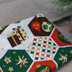 Nahaufnahme des bunten Weihnachtsstoffs mit verschiedenen festlichen Motiven für die handgemachten Anhänger.
